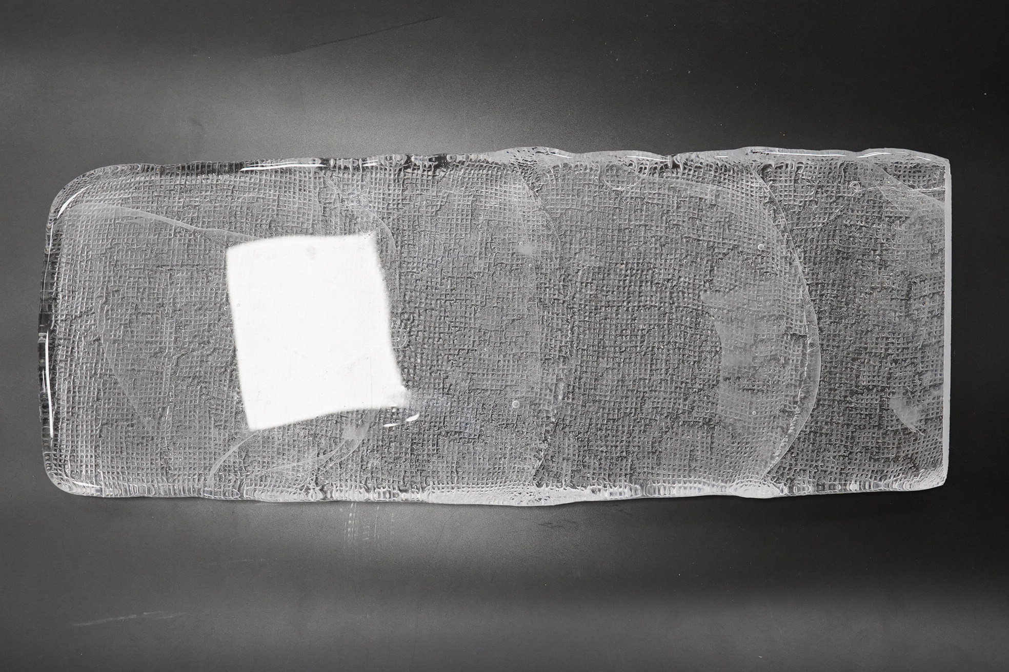 A Mary Canny art glass sandblasted hessian textured glass sculpture, 42cm x 16cm